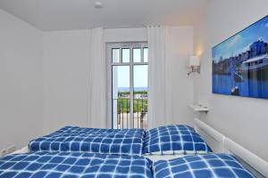 ハイリゲンダムにあるLinden-Palais Wohnung 14のベッドルーム(青いベッド1台、窓付)