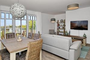 ein Wohnzimmer mit einem Tisch und einem Sofa in der Unterkunft Linden-Palais Wohnung 14 in Heiligendamm