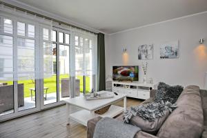 - un salon avec un canapé et une télévision dans l'établissement Linden-Palais Wohnung 09, à Heiligendamm
