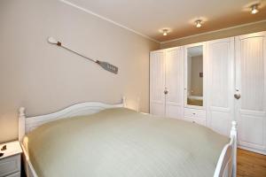ハイリゲンダムにあるLinden-Palais Wohnung 09の白いベッドルーム(ベッド1台、キャビネット付)