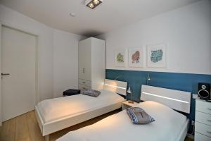 2 camas en una habitación de color azul y blanco en Linden-Palais Wohnung 29, en Heiligendamm