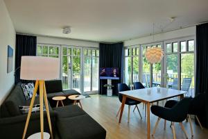 a living room with a table and chairs at Linden-Palais Wohnung 29 in Heiligendamm