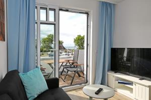 ハイリゲンダムにあるLinden-Palais Wohnung 31のリビングルーム(ソファ、テレビ、バルコニー付)