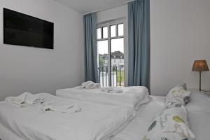 ハイリゲンダムにあるLinden-Palais Wohnung 31の窓付きの客室で、白いベッド2台が備わります。