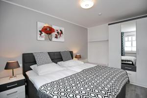 ハイリゲンダムにあるLinden-Palais Wohnung 23のベッドルーム(白黒のベッド1台、鏡付)