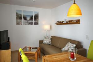 uma sala de estar com um sofá e uma mesa em Linden-Palais Wohnung 27 em Heiligendamm
