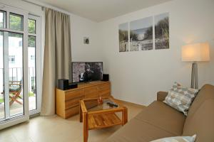 uma sala de estar com um sofá e uma televisão em Linden-Palais Wohnung 27 em Heiligendamm