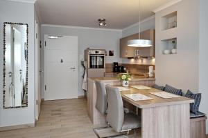 a kitchen and dining room with a wooden table and chairs at Villa Sanddorn Wohnung 16 in Börgerende-Rethwisch