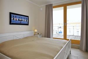 a bedroom with a bed with a television on the wall at Villa Sanddorn Wohnung 16 in Börgerende-Rethwisch