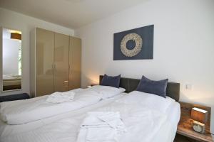 ハイリゲンダムにあるLinden-Palais Wohnung 08のベッドルーム1室(白い大型ベッド2台、青い枕付)