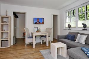 uma sala de estar com um sofá e uma mesa em Linden-Palais Wohnung 08 em Heiligendamm