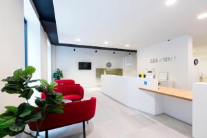 a waiting room at a fertility clinic with red chairs at Yugo Explore - Lee Point in Cork