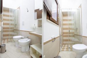 ein Badezimmer mit 2 WCs, einem Waschbecken und einer Dusche in der Unterkunft Alcova di relax in Castellammare del Golfo