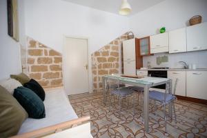 ein Wohnzimmer mit einem Tisch und einer Küche in der Unterkunft Alcova di relax in Castellammare del Golfo