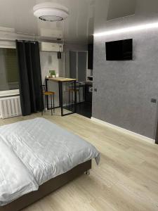 1 dormitorio con 1 cama y 1 mesa con sillas en Апартаменты VIP в центре города. Гагарина 39, en Krivoy Rog