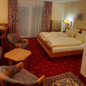 a hotel room with a bed and a table and chairs at Waldgasthof Lorchenmühle UG in Wallenfels