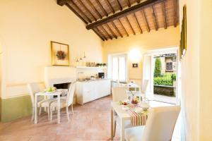 La Chiocarella في بينزا: مطبخ وغرفة طعام مع طاولة وكراسي