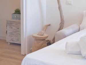 a bedroom with a bed and a table with a stool at Medusa Apartment - Lungomare in Finale Ligure