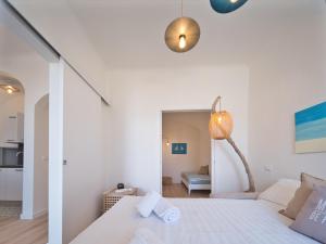 a white bedroom with a bed and a lamp at Medusa Apartment - Lungomare in Finale Ligure +14 photos