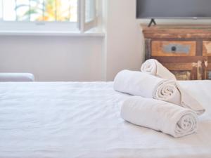 a pile of towels sitting on a bed at Medusa Apartment - Lungomare in Finale Ligure