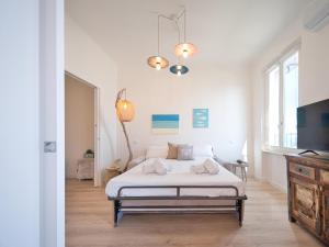 a white bedroom with a bed and a window at Medusa Apartment - Lungomare in Finale Ligure