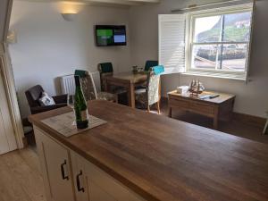 a kitchen and living room with a table and a window at Whitby Sea View Cottage in Whitby