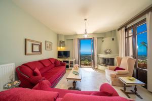a living room with a red couch and two chairs at Saint George Castle Villa with sea view in Kefallonia