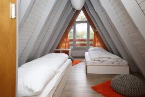 two beds in a room with a window at Ferienhäuser Campingplatz in Kinding