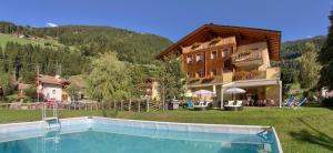 una casa con piscina delante de una casa en Naturresidenz Theistadl, en Ultimo
