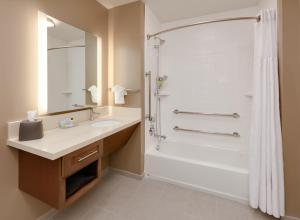 a bathroom with a shower and a sink and a toilet at Staybridge Suites - Oklahoma City - Downtown, an IHG Hotel in Oklahoma City