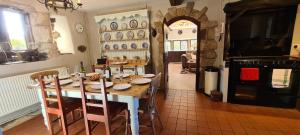 a dining room with a table with chairs and an oven at Greave farmhouse 3-Bed Cottage in Todmorden in Todmorden