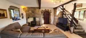 a living room with a couch and a tv and a fireplace at Greave farmhouse 3-Bed Cottage in Todmorden in Todmorden