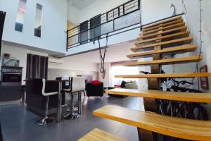 a room with a table and some chairs and stairs at Loft 5* Centre, terras. park babyfoot clim vélos in Montélimar