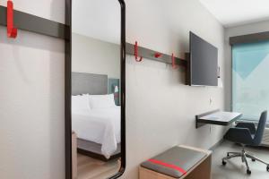 a mirror in a room with a bed and a desk at Avid hotels - Ft Lauderdale Airport - Cruise, an IHG Hotel in Fort Lauderdale