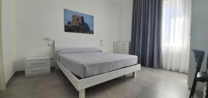 una camera bianca con un letto e una finestra di InCentroScalea B&B a Scalea