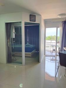 a bedroom with a bed in a glass room at Grand Beach 2, apartment by Wheelie75 in Ban Tha Fat