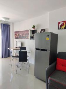 a kitchen with a refrigerator and a table with chairs at Grand Beach 2, apartment by Wheelie75 in Ban Tha Fat