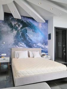 a bedroom with a large bed with a painting on the wall at Hotel George suite 1 in Limenas
