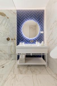 a bathroom with a blue tiled wall with a mirror at Eagle's Nest Rooms and Apartments in Ljubljana