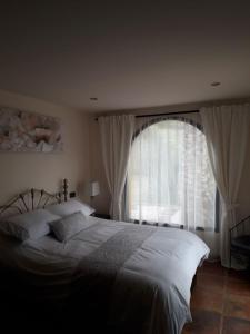 sypialnia z łóżkiem i dużym oknem w obiekcie Casita Blanco w Maladze +27 zdjęć