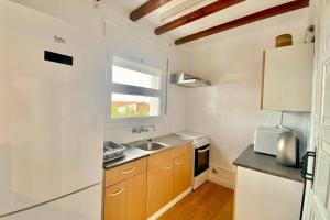 eine kleine Küche mit Spüle und Fenster in der Unterkunft Alemanya 38 in Torroella de Montgrí