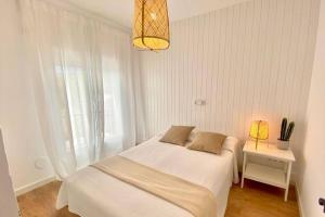 ein weißes Schlafzimmer mit einem Bett und einem Fenster in der Unterkunft Alemanya 38 in Torroella de Montgrí + 14 Fotos