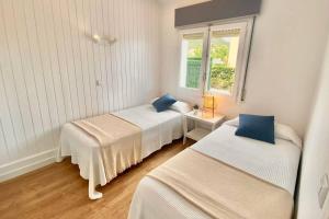 ein Schlafzimmer mit zwei Betten und einem Fenster in der Unterkunft Alemanya 38 in Torroella de Montgrí