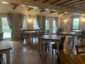 a restaurant with wooden tables and chairs and windows at The Sun Inn in Penrith