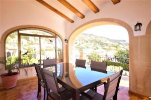 a dining room with a table and chairs on a balcony at Villa- Calas in Jávea