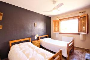 a bedroom with two beds and a black wall at Villa- Calas in Jávea +19 photos