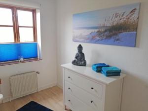 a room with a statue sitting on top of a dresser at Ferienwohnung "Luv" Grube Ostsee in Grube +46 photos