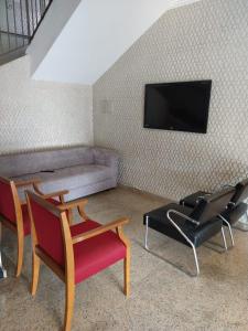 sala de estar con 2 sillas y sofá en Alzira Plaza Hotel, en São Lourenço