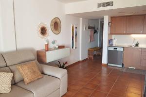 ein Wohnzimmer mit einem Sofa und einer Küche in der Unterkunft Casa Oliveres Beach en L' Ampolla in Perelló