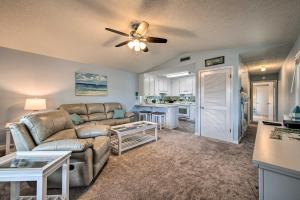 a living room with a couch and a kitchen at PCB Resort Condo with Private Balcony and 3 Pools! in Panama City Beach